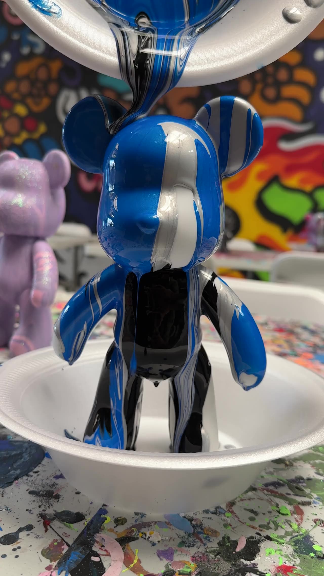 Paint pouring over a BearDrips bear in the studio